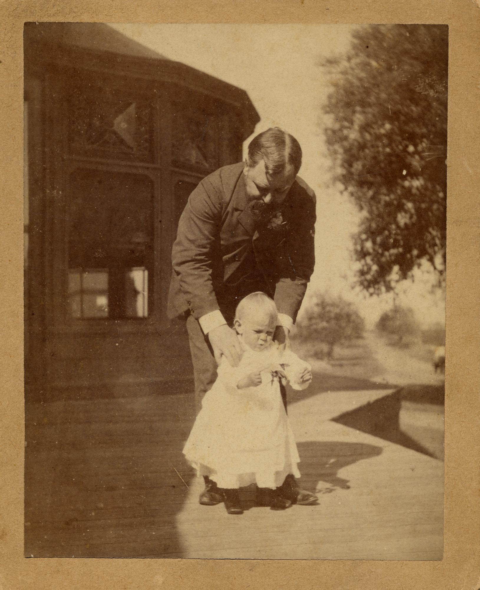 Photograph of Robert Todd Lincoln bending down to hold his son, Abraham "Jack" II, shoulders circa 1874. 